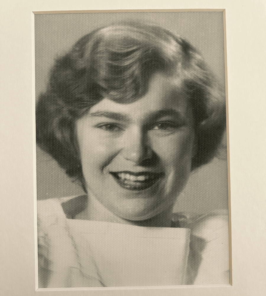 A young woman with short, wavy hair smiles in a black-and-white portrait.