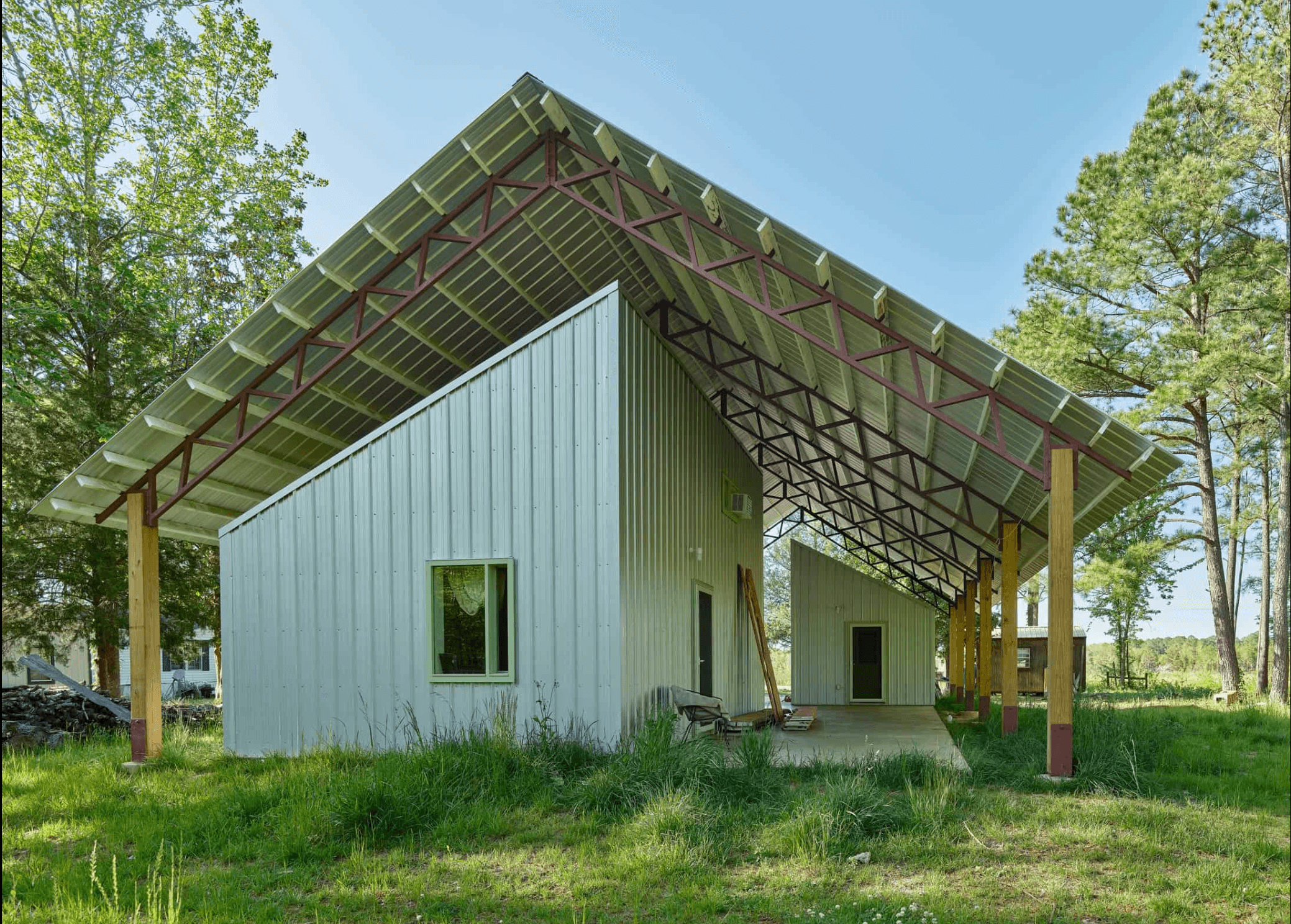 Modern architectural home with an angular roof and surrounded by greenery.
